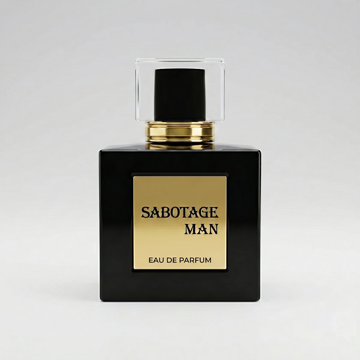 Front view of Sabotage Man 100ml Eau de Parfum in an opaque square black glass bottle with gold label and clear rectangular cap against a light gray background